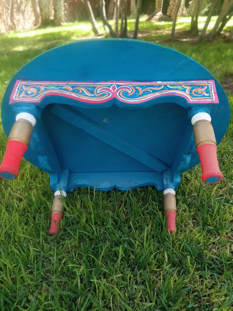 Blue decorative object with pink accents on a grassy background