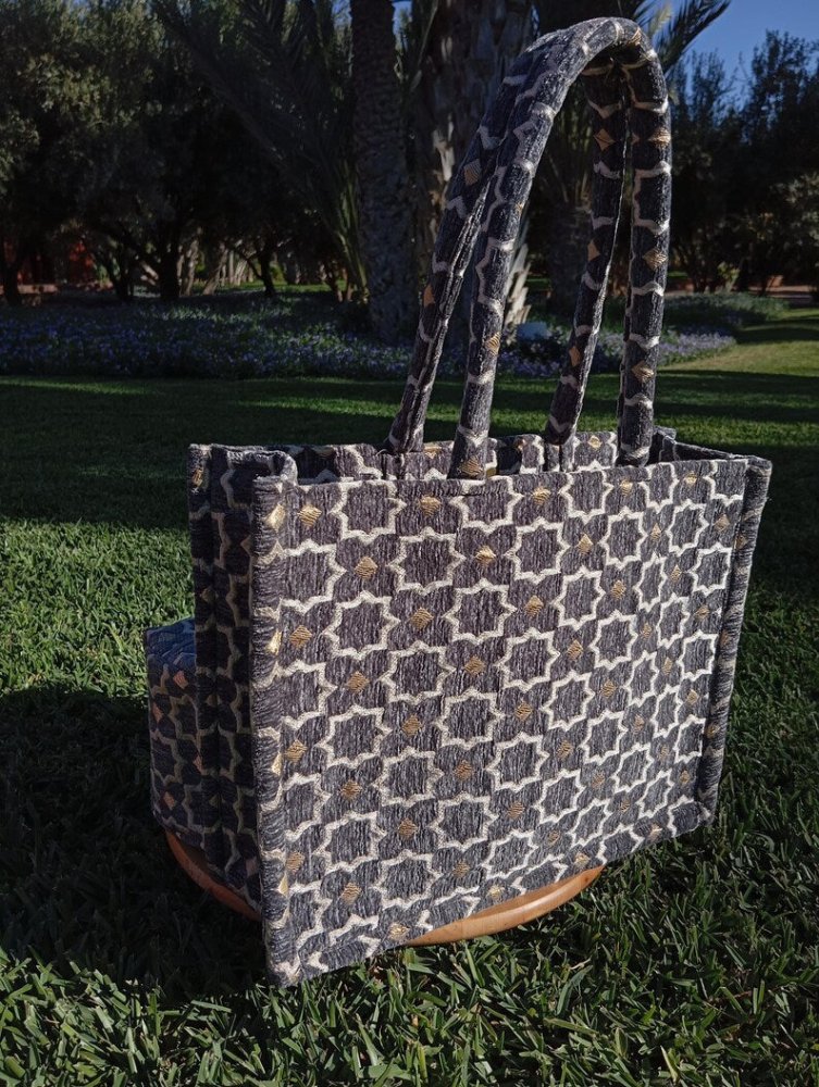 Patterned tote bag on grass with trees in the background