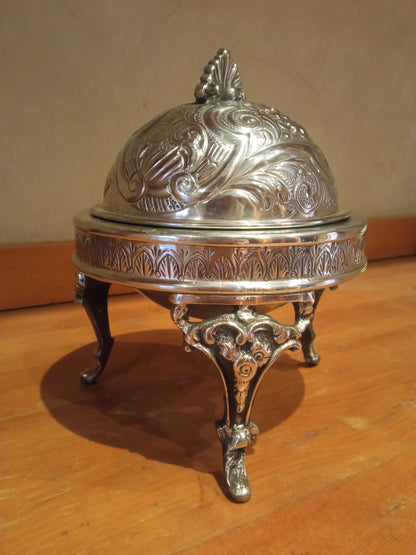 Silver decorative box with a lid on a wooden surface