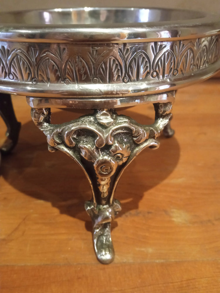 Silver ornate dish on a wooden surface