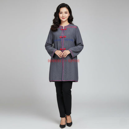 Woman wearing a gray coat with red accents on a plain background