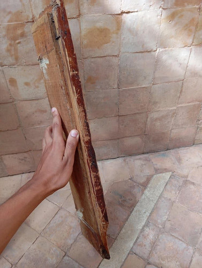 Hand holding an old, worn book against a stone wall background