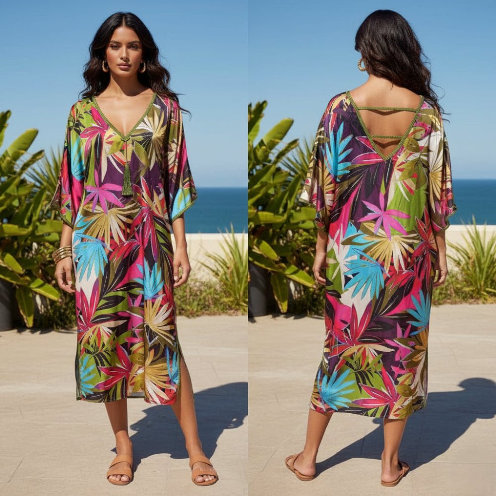 Woman wearing a colorful tropical patterned dress by the ocean.