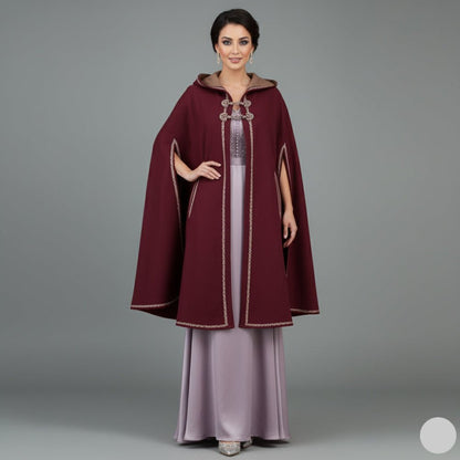 Woman wearing a burgundy cape over a light purple dress on a gray background