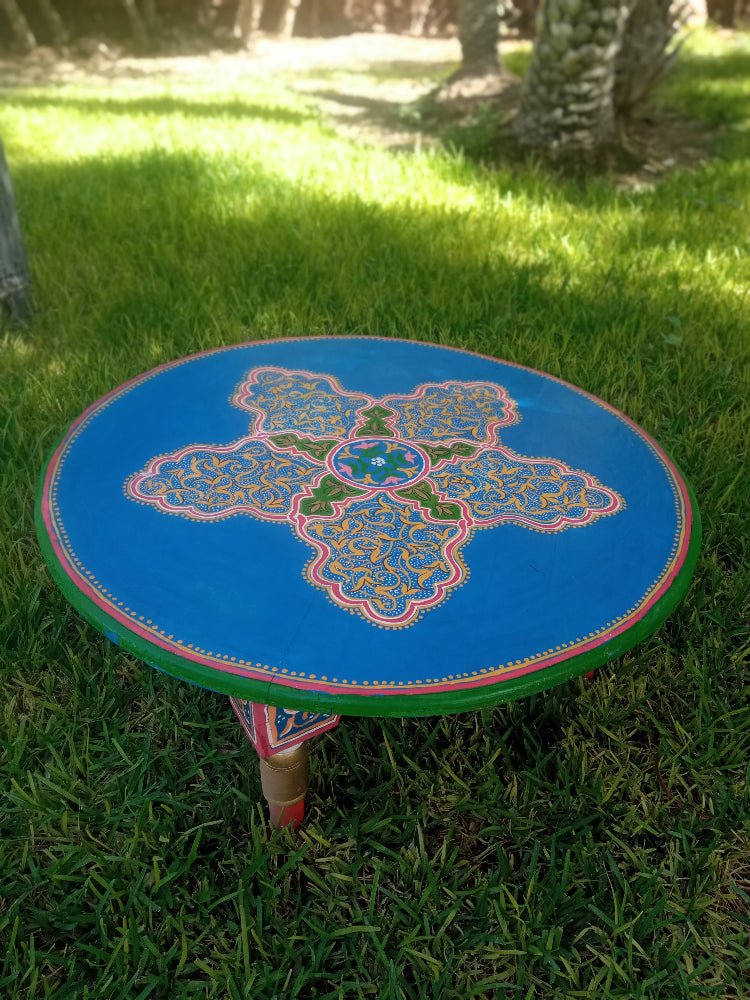 Decorative round moroccan table with a colorful design on grass