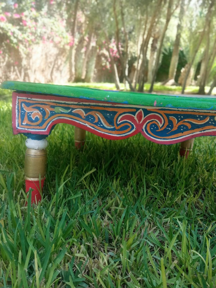 Colorful table with intricate designs on a grassy area