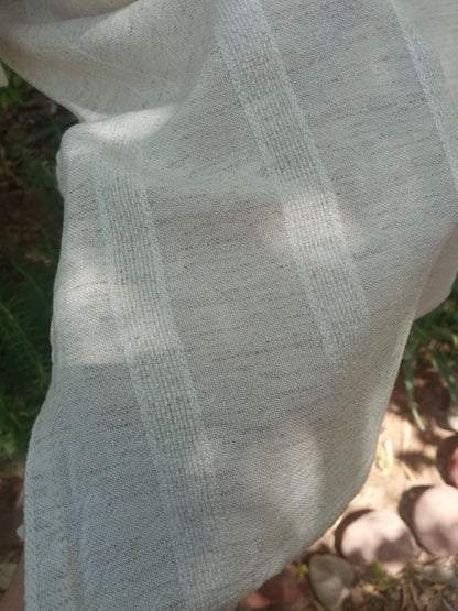 Close-up of a textured fabric with a checkered pattern against a natural background.