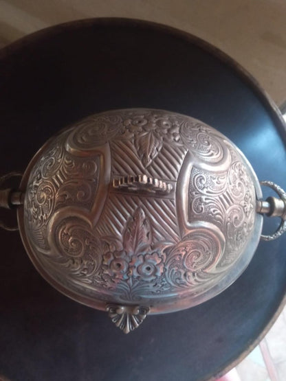 Decorative metal object with intricate patterns on a dark background