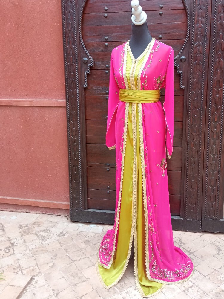 Mannequin wearing a pink and yellow dress in front of a wooden door.