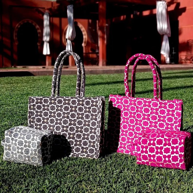 Two patterned bags, one black and white and one pink and white, on grass.