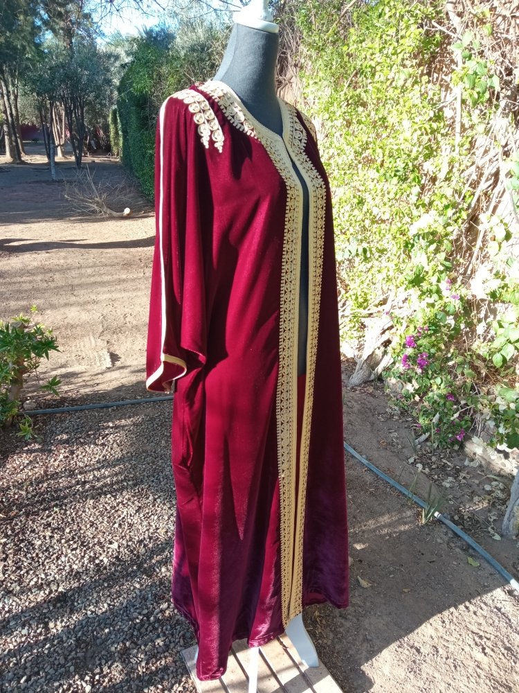 Red dress with gold trim on a mannequin outdoors
