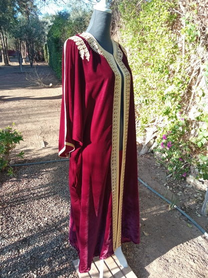 Red dress with gold trim on a mannequin outdoors
