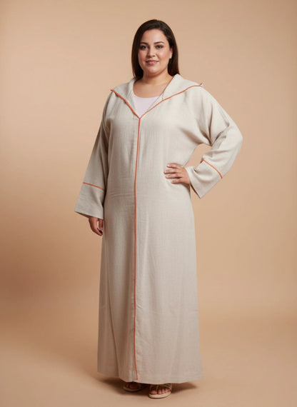 Woman wearing a beige Moroccan djellaba with orange trim on a beige background