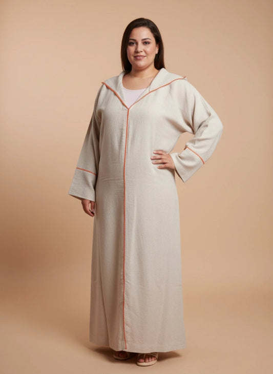 Woman wearing a beige Moroccan djellaba with orange trim on a beige background