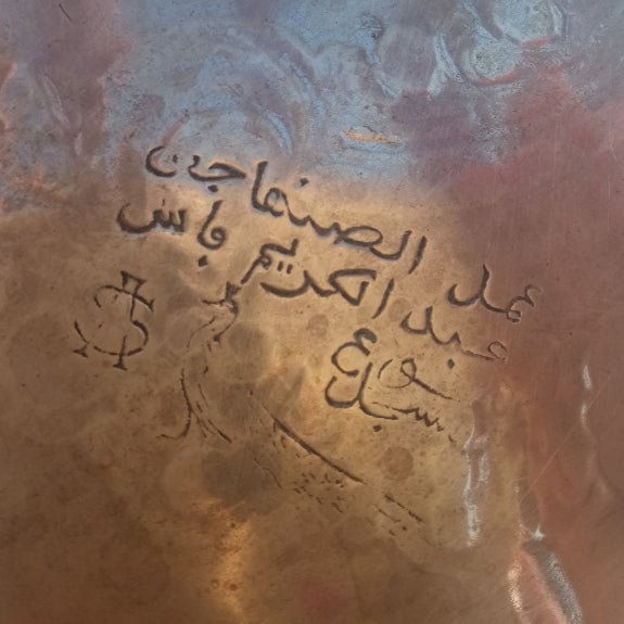 Close-up of a textured surface with engraved text in Arabic.