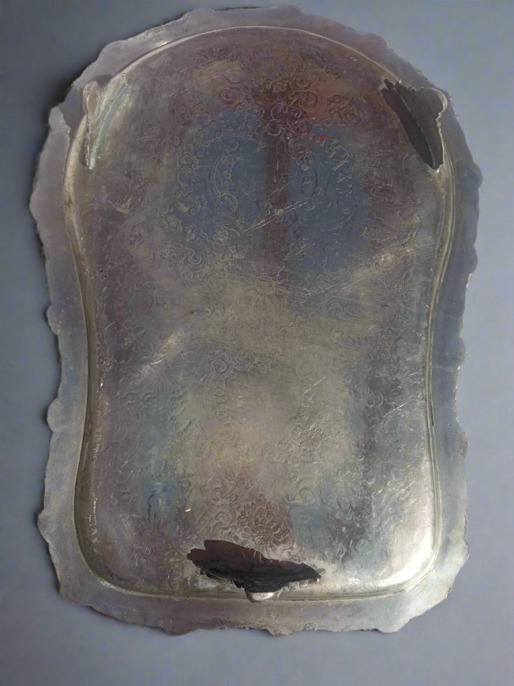 Silver tray with intricate designs on a white background