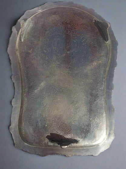 Silver tray with intricate designs on a white background