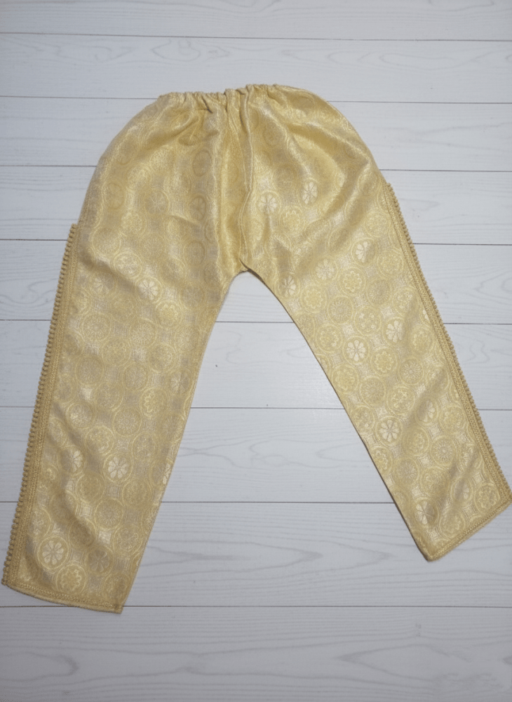 Beige embroidered pants on a light wooden floor
