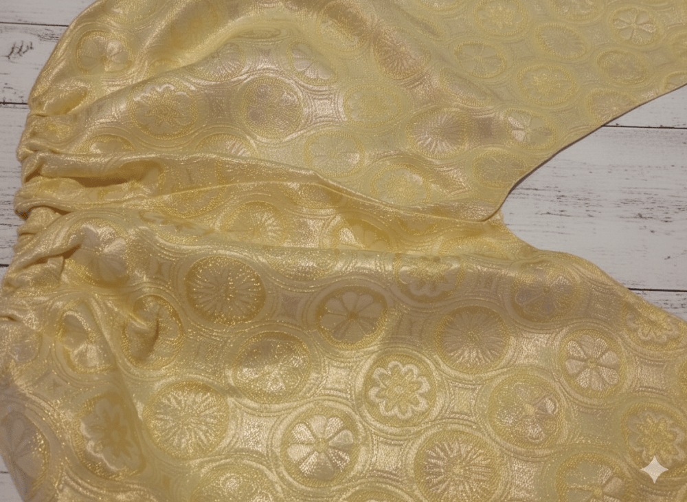 Gold pants vintage with intricate patterns on a wooden surface