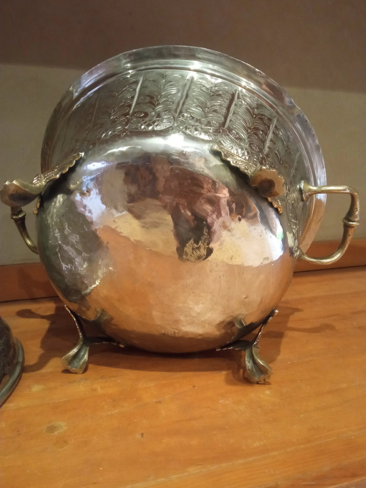 Silver metal container with handles on a wooden surface